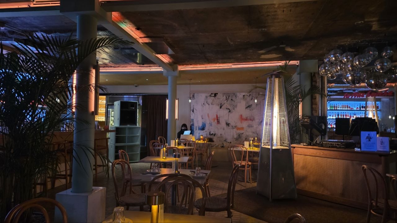 Interior of Bar La Fine Bouche with bentwood chairs and a deep bar